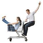 Man pushing shopping cart with girlfriend inside