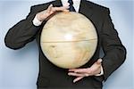 Mid section view of a businessman holding a spinning globe