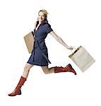 Portrait of a young woman jumping with shopping bags