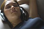 High angle view of a young woman listening to music on headphones