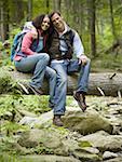Portrait of a young couple sitting on a fallen tree