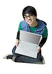 Man with laptop sitting cross legged smiling