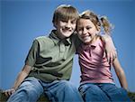 Portrait of a boy sitting with his arm around his sister