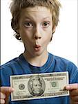 Portrait d'un garçon tenant un billet de vingt dollars