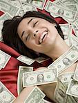 Vue grand angle d'une jeune femme couchée sur papier monnaie