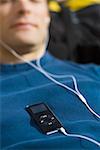 Close-up of a young man listening to an MP3 Player
