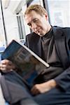 Senior man reading a book on a commuter train