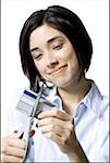 Close-up of a young woman cutting a credit card with a pair of scissors