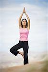 Vue d'angle faible d'une jeune femme faisant du yoga