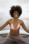 Jeune femme assise sur un bateau de vitesse