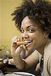 Portrait of a young woman eating a spring roll