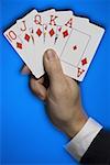 Close-up of a person's hand with a royal flush