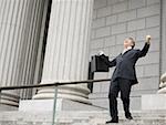 Faible angle vue d'un avocat mâle en riant et en descendant les marches d'un palais de justice