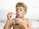 Boy blowing bubbles at the beach