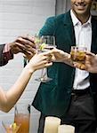 Mid section view of a man toasting drinks with his friends at a party