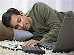 Close-up of a man sleeping next to his laptop