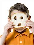 Portrait d'un garçon regardant dans une tranche de pain