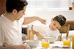 Fils de père et de la jeune prenant son petit déjeuner ensemble