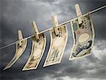 Close-up of Japanese currency pegged to a clothesline