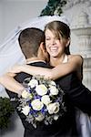 Close-up of a newlywed couple embracing each other and smiling