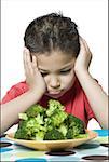 Gros plan d'un garçon regardant le brocoli dans un plat