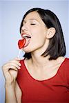 Close-up of a young woman licking a lollipop