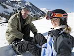 Close-up eines Vaters, der seine Tochter helfen setzen auf einem Snowboard