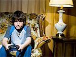 Boy with video game controller on sofa