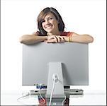 Girl leaning on computer monitor smiling