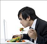 Voir le profil:: un homme d'affaires, manger et à l'aide d'un ordinateur portable