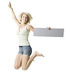 Portrait of a young woman holding a blank sign and jumping