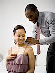 Man putting on a necklace around a woman's neck