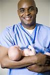 Male nurse or doctor holding newborn baby