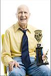 Portrait of a senior man holding a trophy