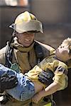 Firefighter carrying a wounded boy