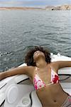 Vue grand angle d'une jeune femme reposant sur un bateau de vitesse