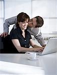 Close-up of a businessman kissing a businesswoman on the cheek