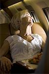 A senior woman sleeping in an airplane