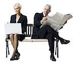 Businessman and businesswoman sitting on a bench