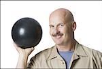 Porträt eines Reifen Mannes hält eine Bowling-Kugel