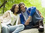 Portrait of a young couple sitting on a rock and smiling