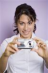 Portrait of a woman holding a digital camera