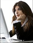 Gros plan d'une femme d'affaires assis devant un ordinateur avec sa main sous son menton