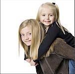 Close-up of a girl riding piggyback on her sister