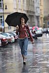 Adolescente marche sous la pluie avec un parapluie