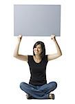 Portrait of a young woman holding up a blank sign