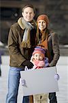 Homme et femme fille holding vierge signent à l'extérieur en hiver