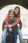 Portrait of a teenage boy giving a piggyback ride to a teenage girl