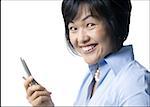 Portrait d'une femme adulte mid tenant un téléphone à clapet et souriant