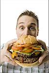 Portrait d'un jeune homme tenant un hamburger